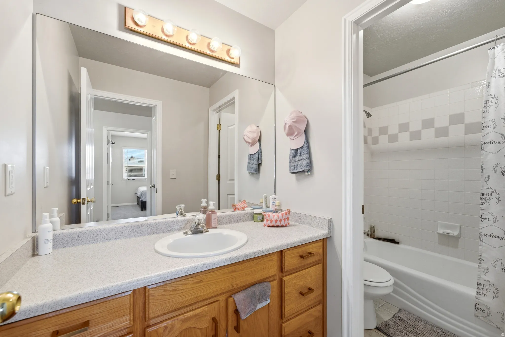 Bathroom featuring a vanity with a light-colored countertop, an integrated sink, and wood-finish cabinetry