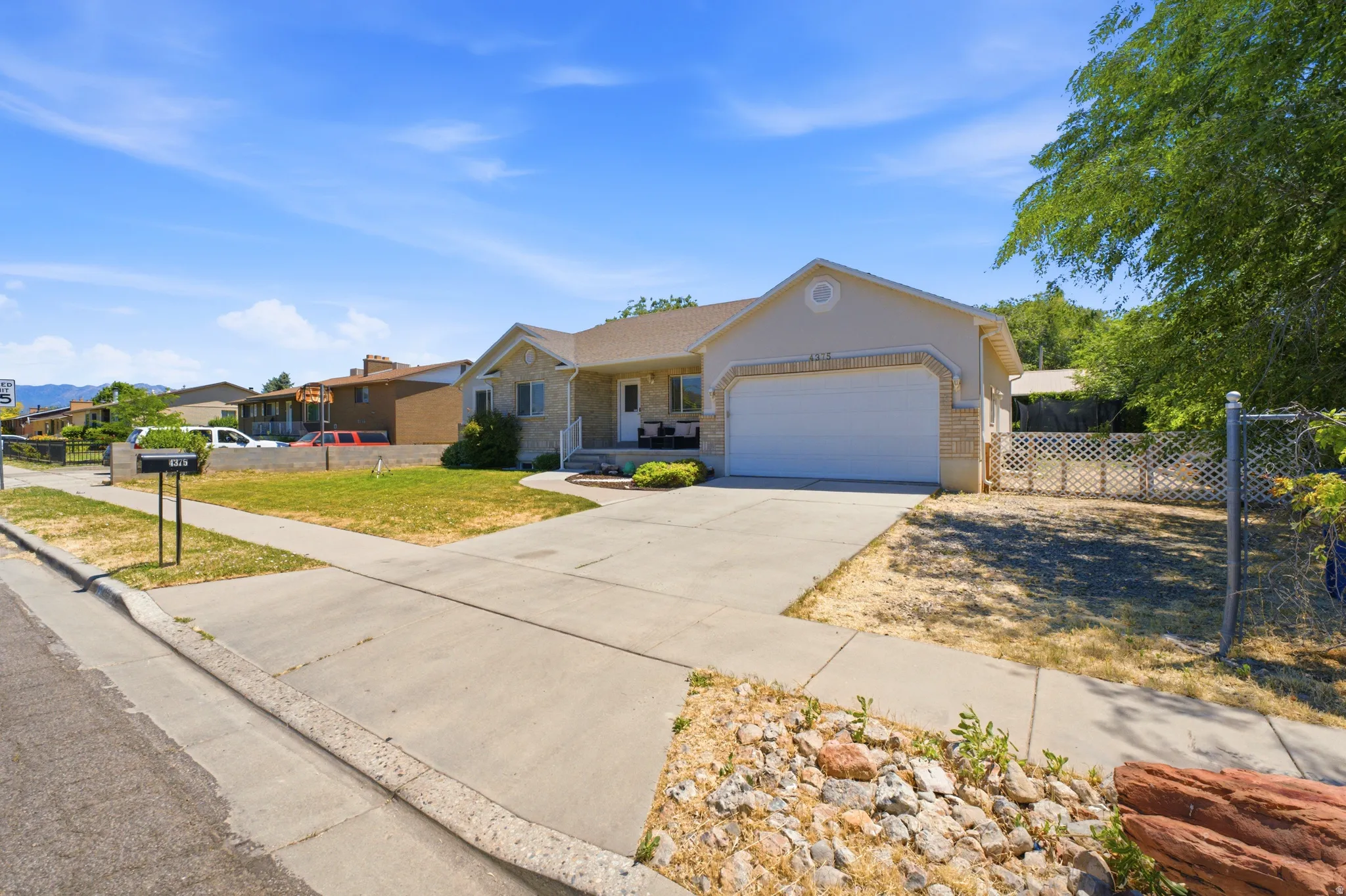 Ranch-style residence featuring a stone and stucco exterior, an attached two-car garage, and a concrete driveway