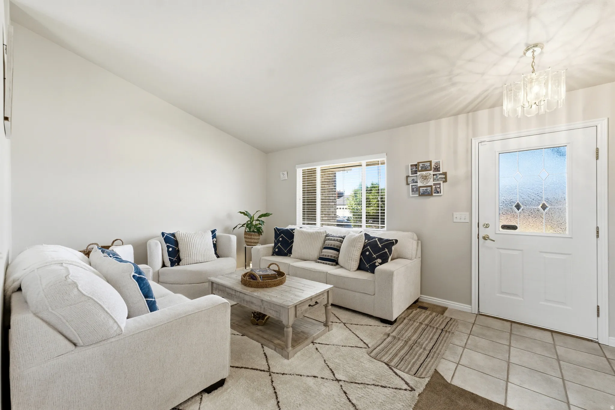 Bright living area featuring a vaulted ceiling and a decorative front entry door with leaded glass