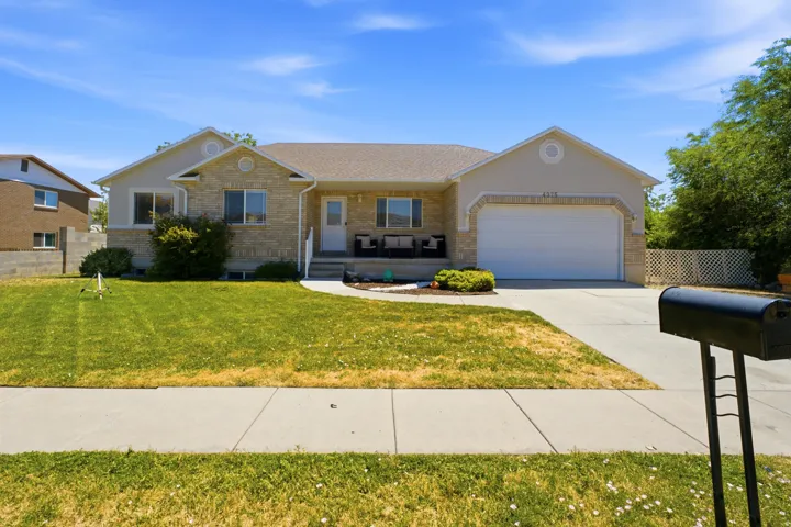 Single-story residence featuring a two-car garage, stone and stucco exterior, front porch, and concrete driveway