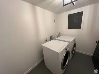 Utility room with light-colored walls, a dark floor, and a single window
