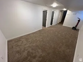 Carpeted room with white painted walls and white baseboards