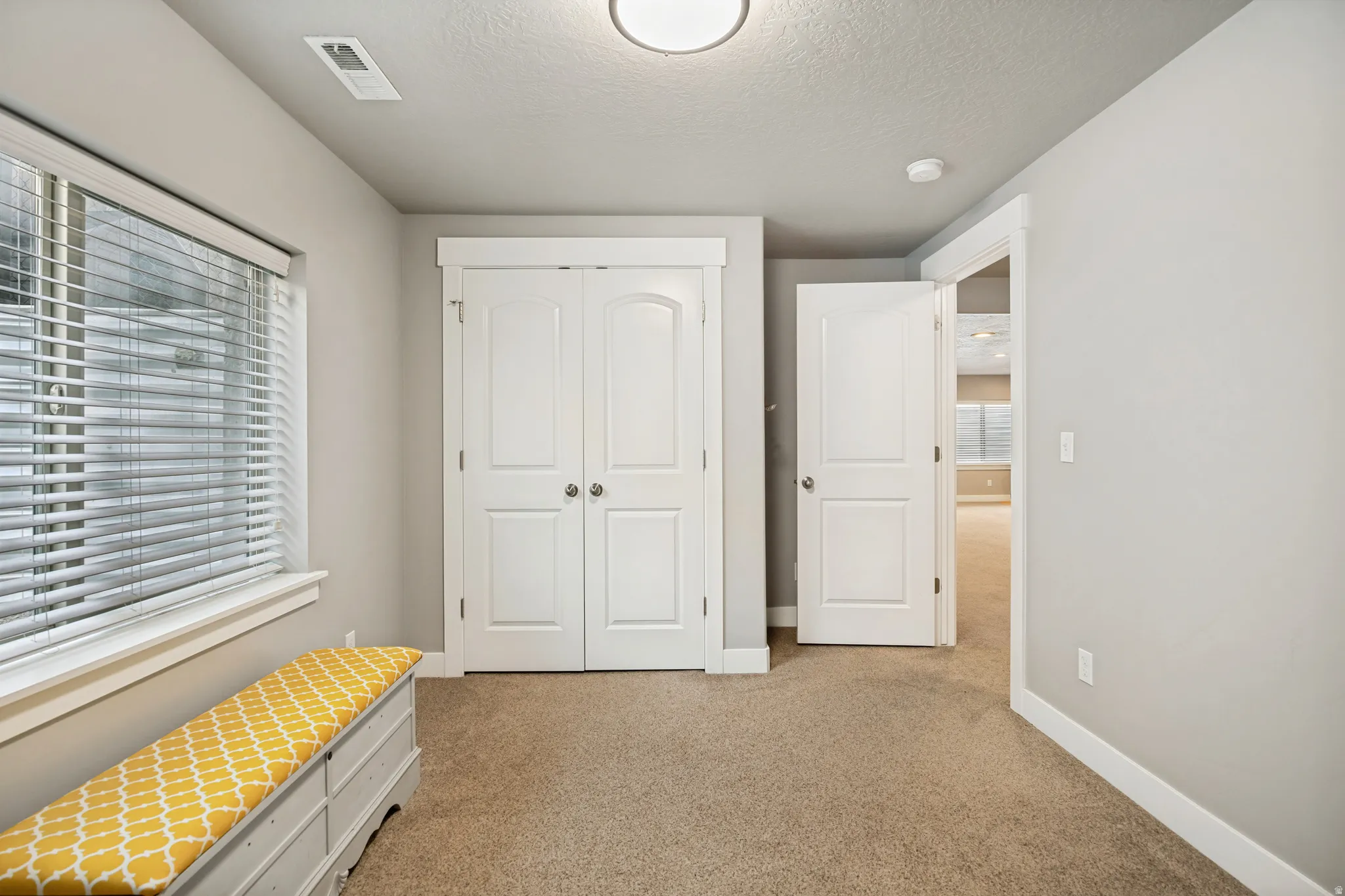 Neutral-toned walls complement plush carpet flooring