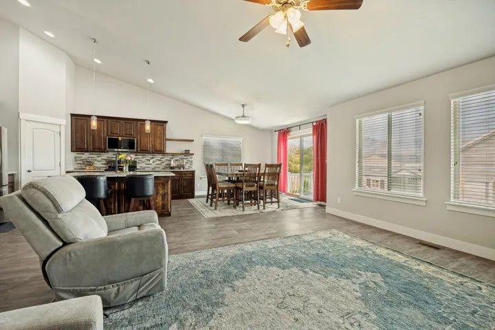Vaulted ceilings extend over the open-concept living area featuring wood-finish flooring