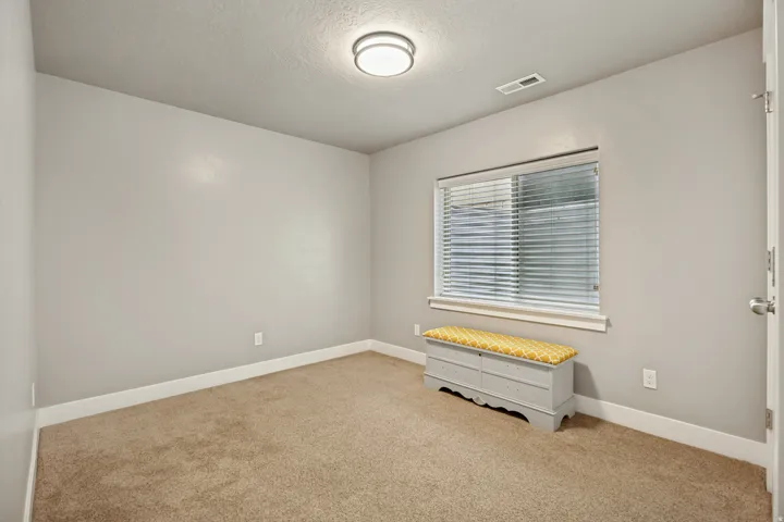Carpeted room with light grey walls and white baseboards