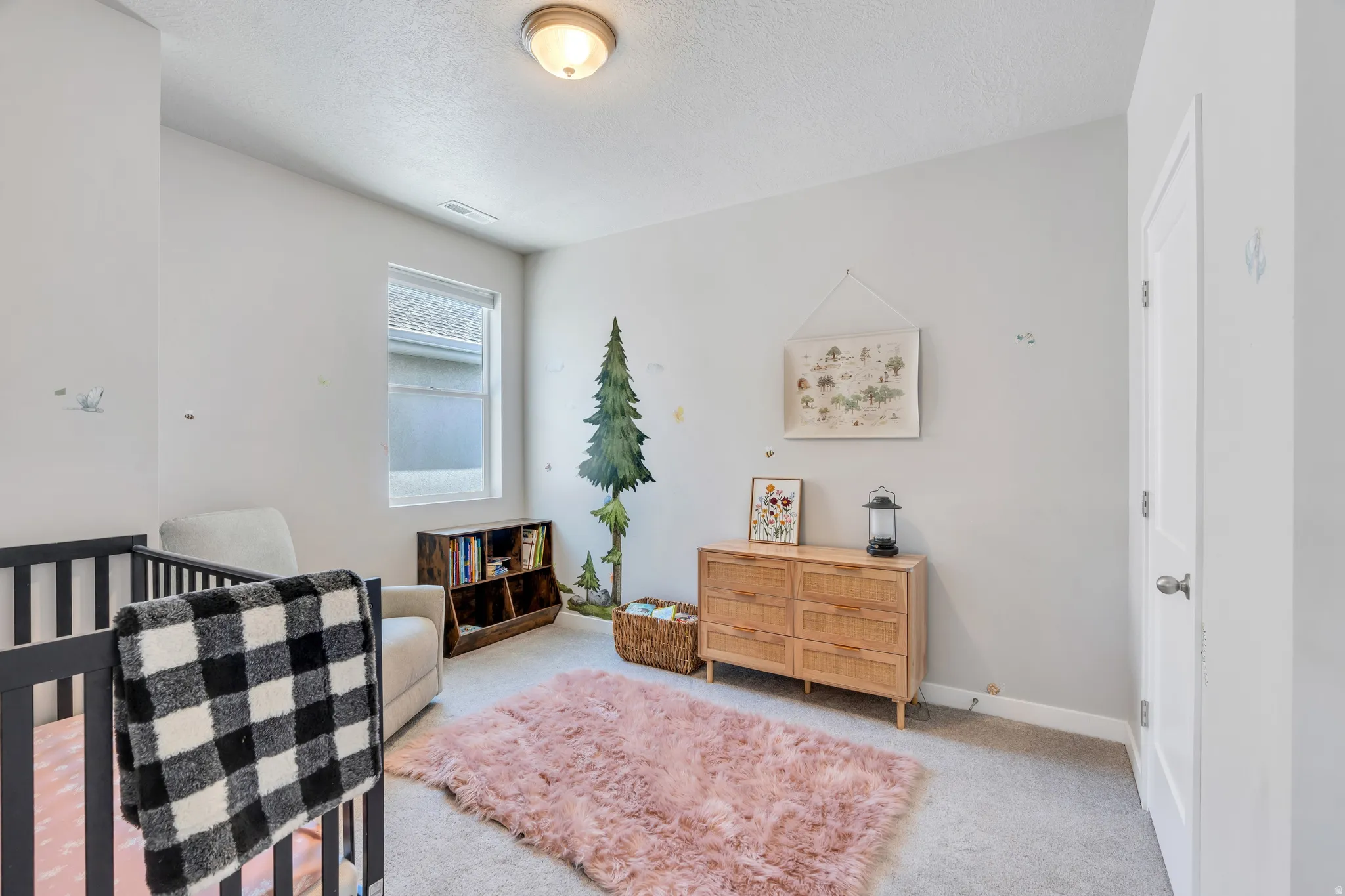 Carpeted room featuring a single window with blinds, a ceiling-mounted light fixture, and a white interior door