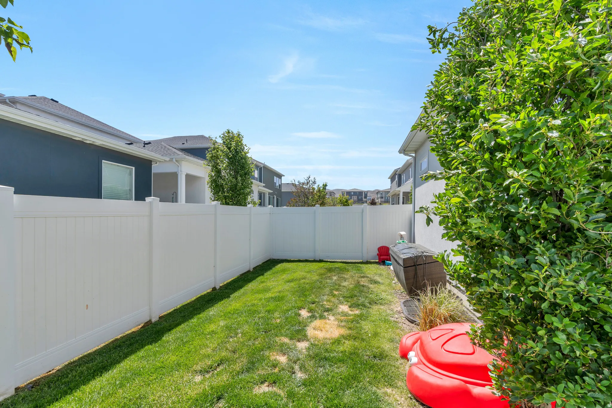 Expansive fenced backyard featuring a manicured lawn, full privacy fencing, and mature perimeter landscaping