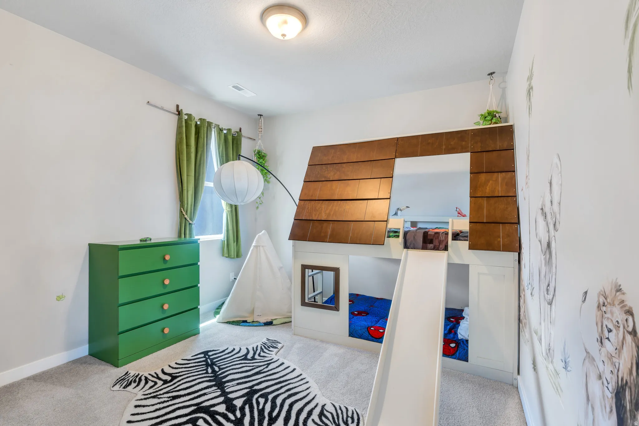 Carpeted room featuring a built-in loft structure with a wood-look facade, a window with green drapes, and an overhead light fixture