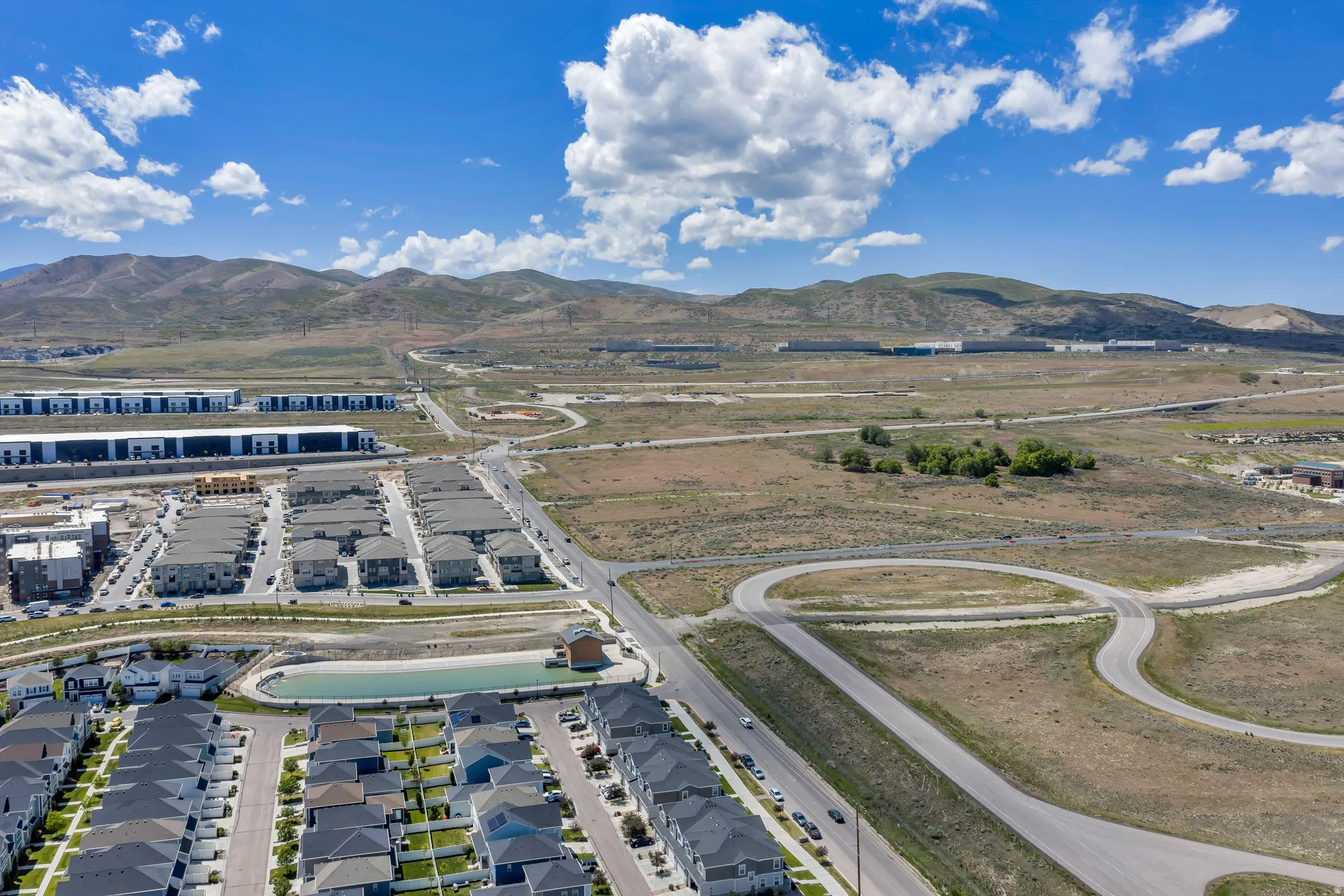 Aerial perspective showcasing residential development with a prominent detention pond