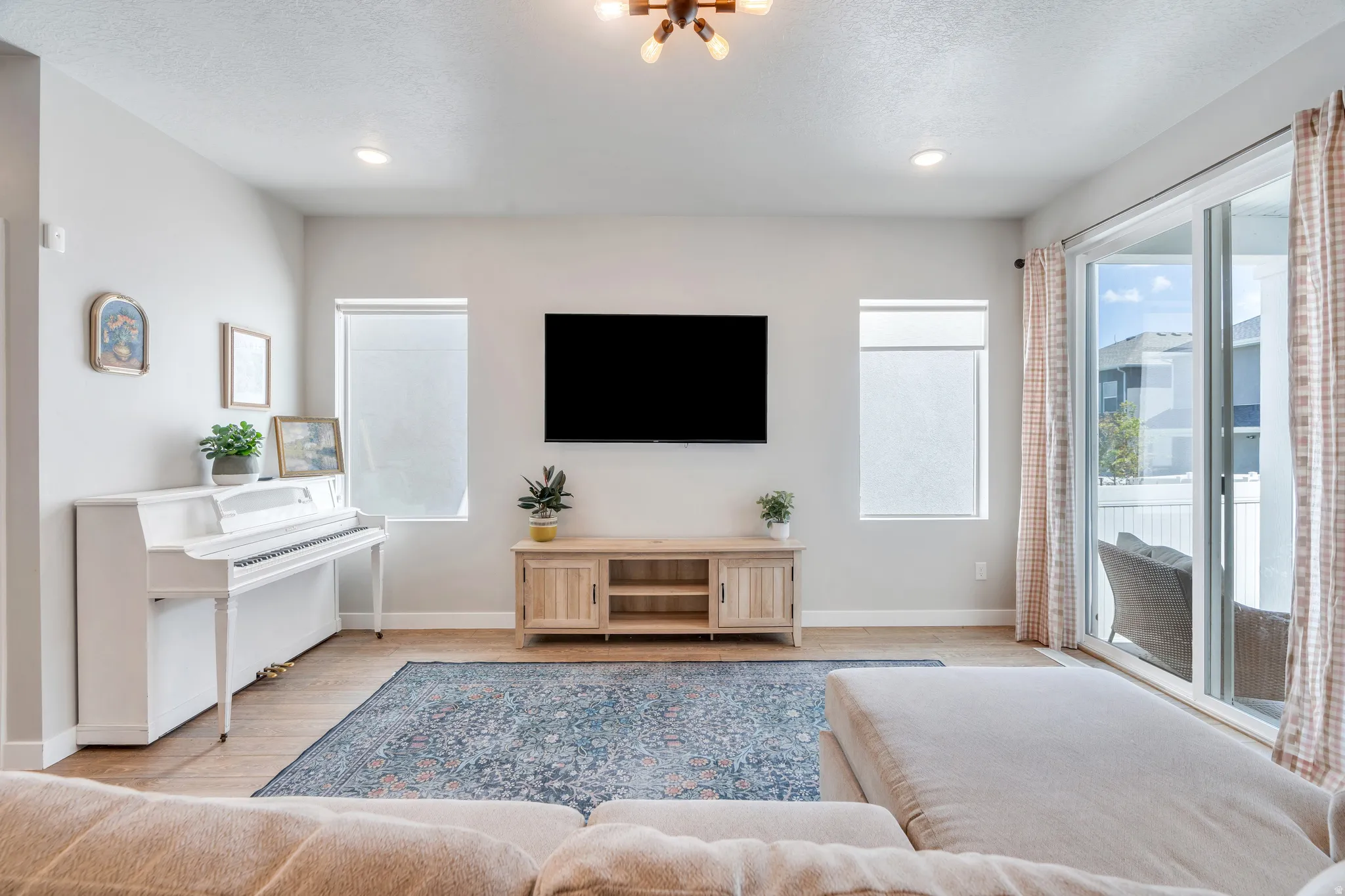 Bright living area featuring wood-finish flooring, recessed lighting, and a contemporary ceiling fixture