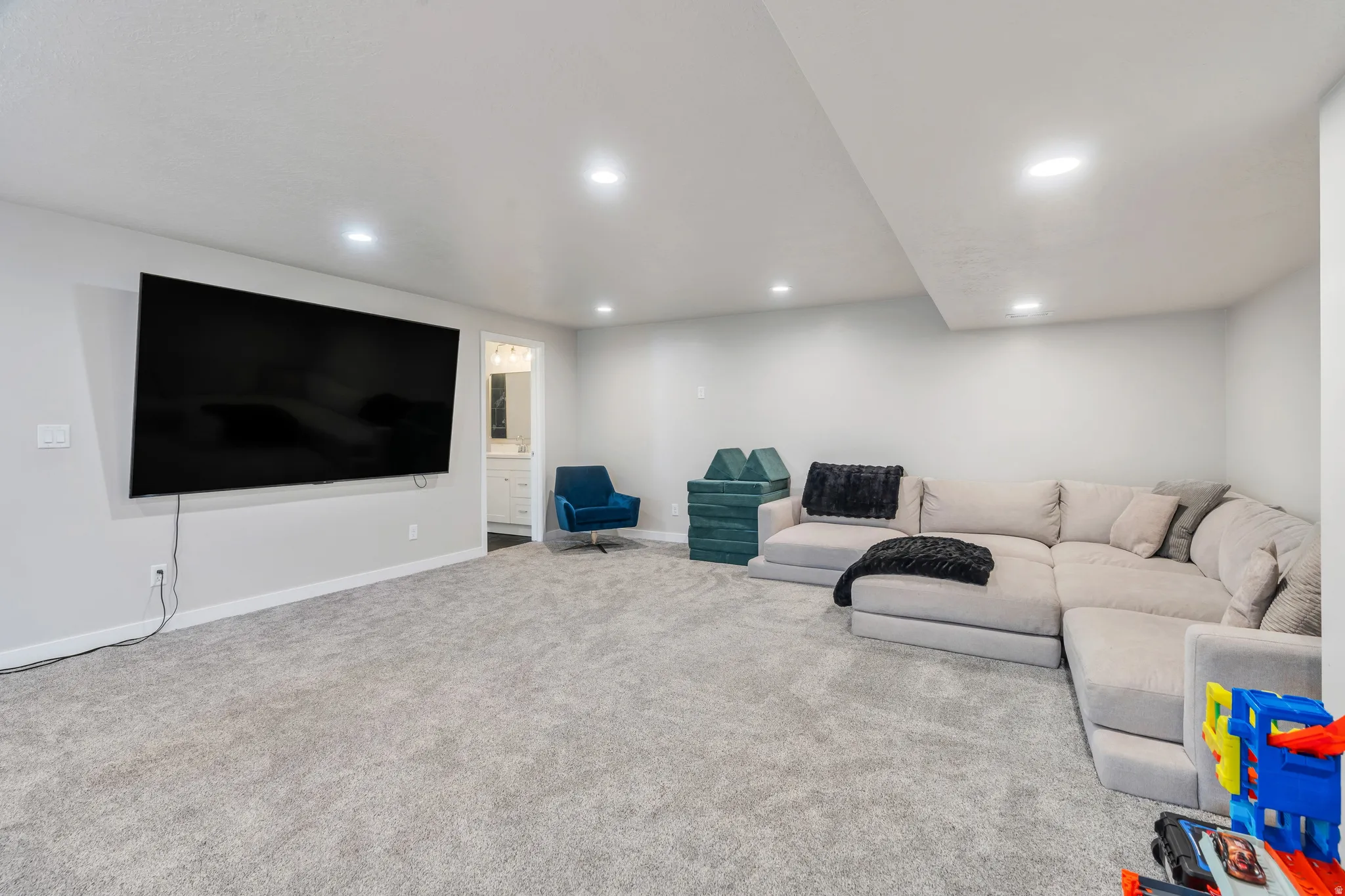 Spacious room featuring light gray carpeting and recessed lighting