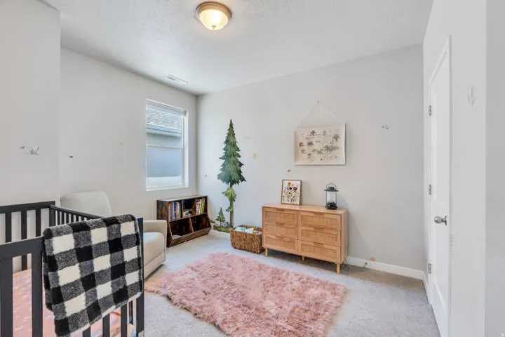 Carpeted room featuring a single window with blinds, a ceiling-mounted light fixture, and a white interior door