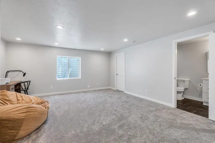 Spacious room with light gray carpeting and recessed lighting