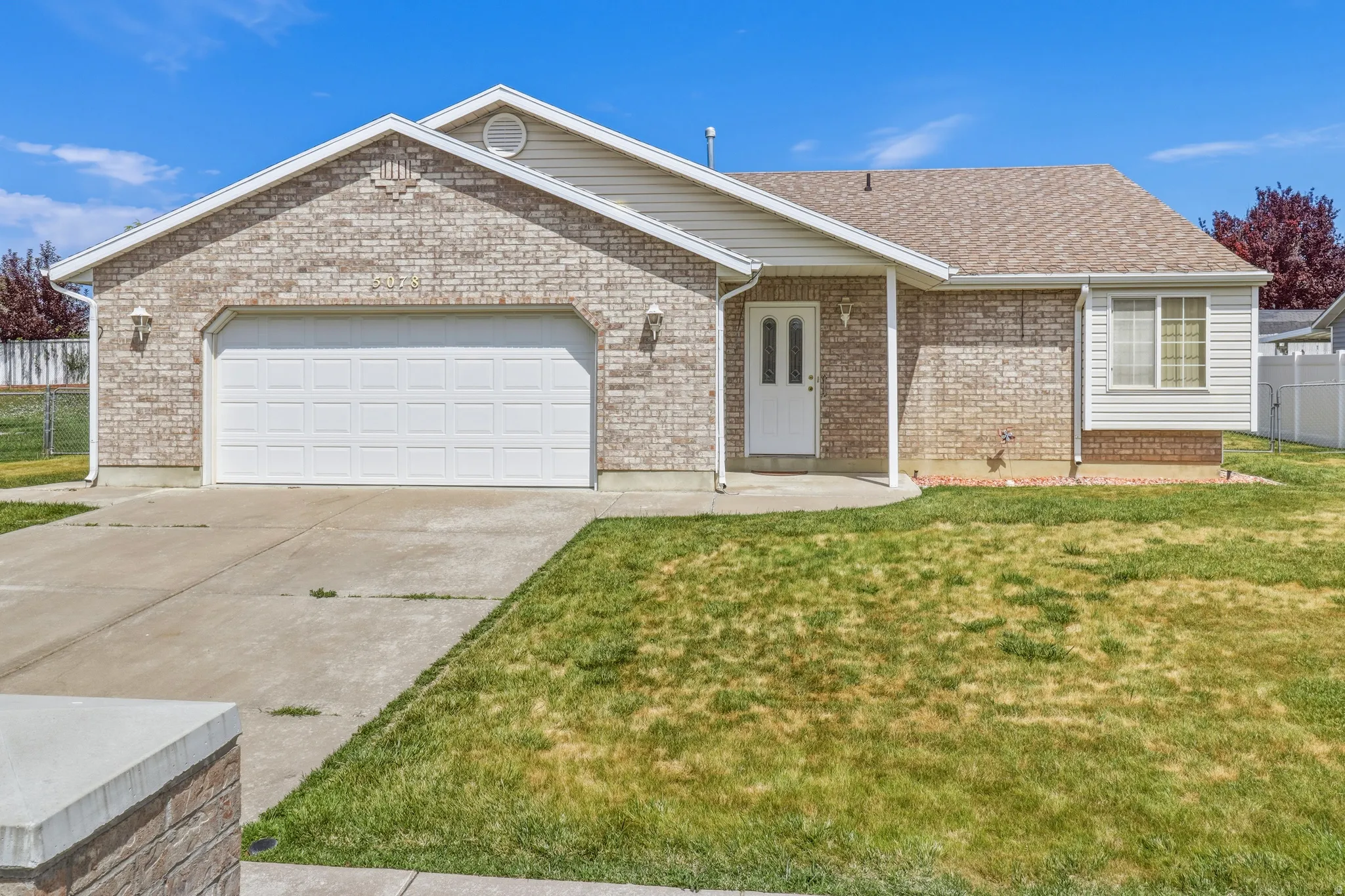 Brick and siding exterior with a two-car garage and a paved driveway
