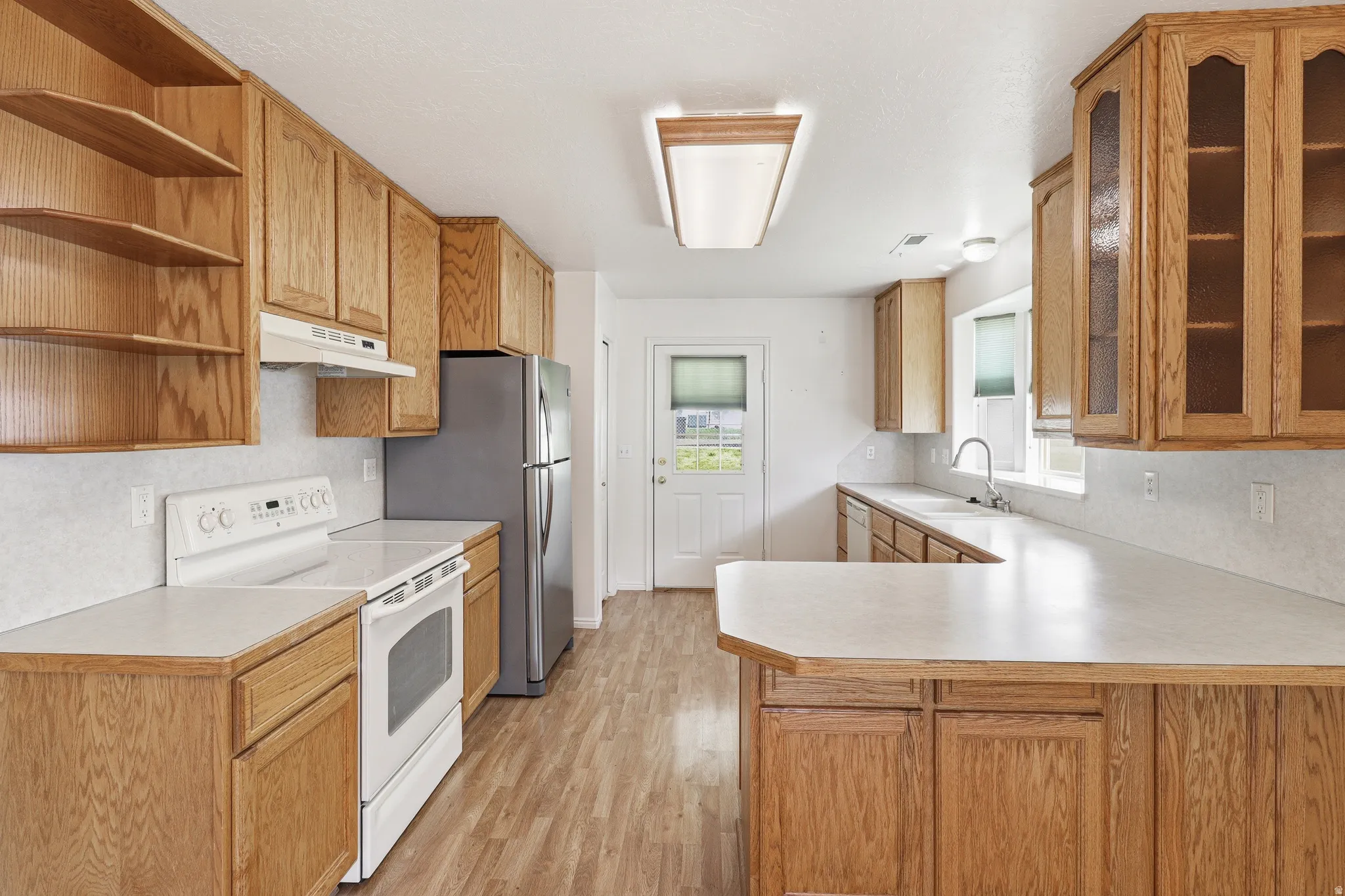Kitchen featuring wood-finish cabinetry, white countertops, and wood-finish flooring