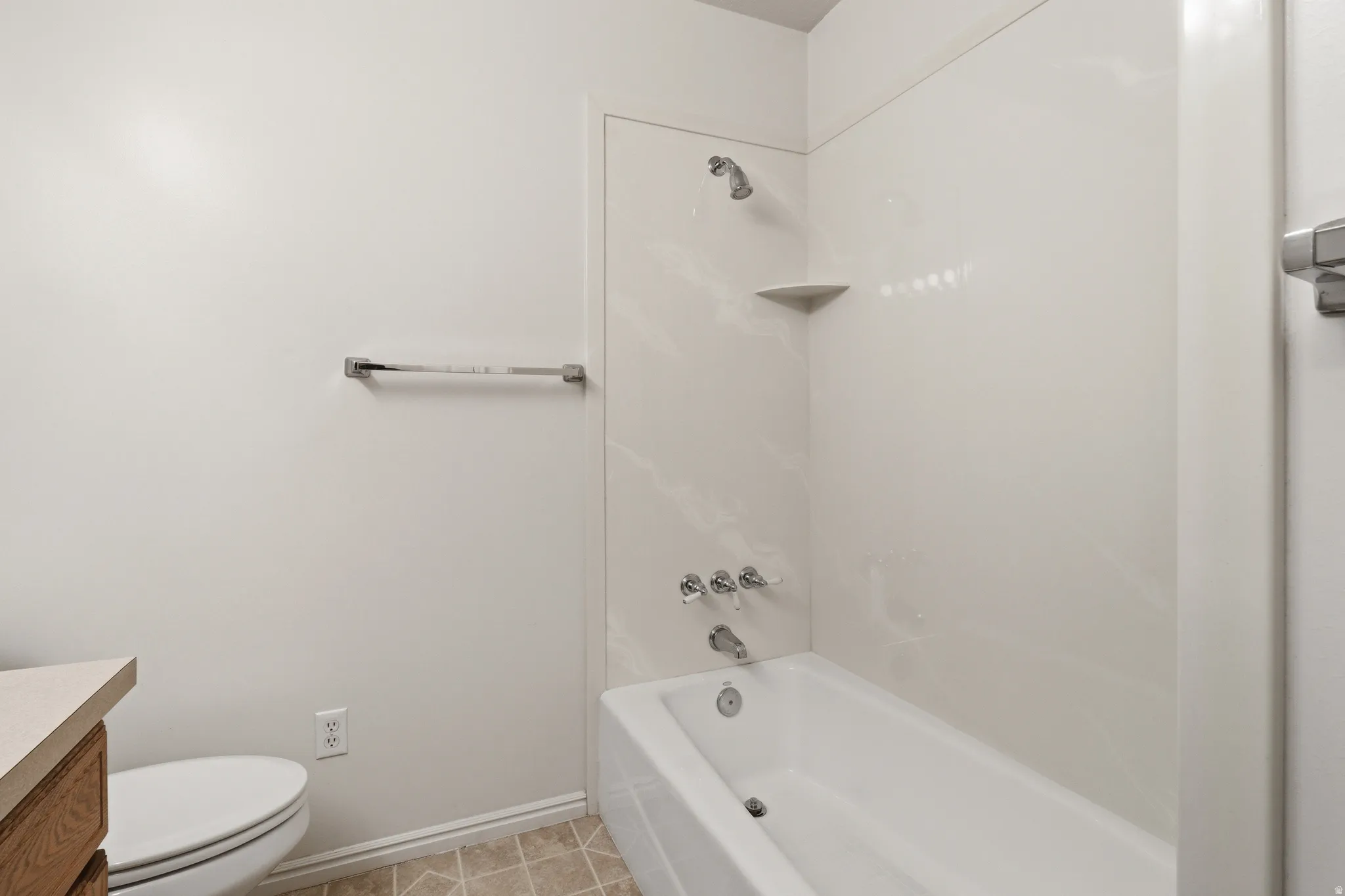 White tub-shower combination with a textured surround and integrated corner shelf