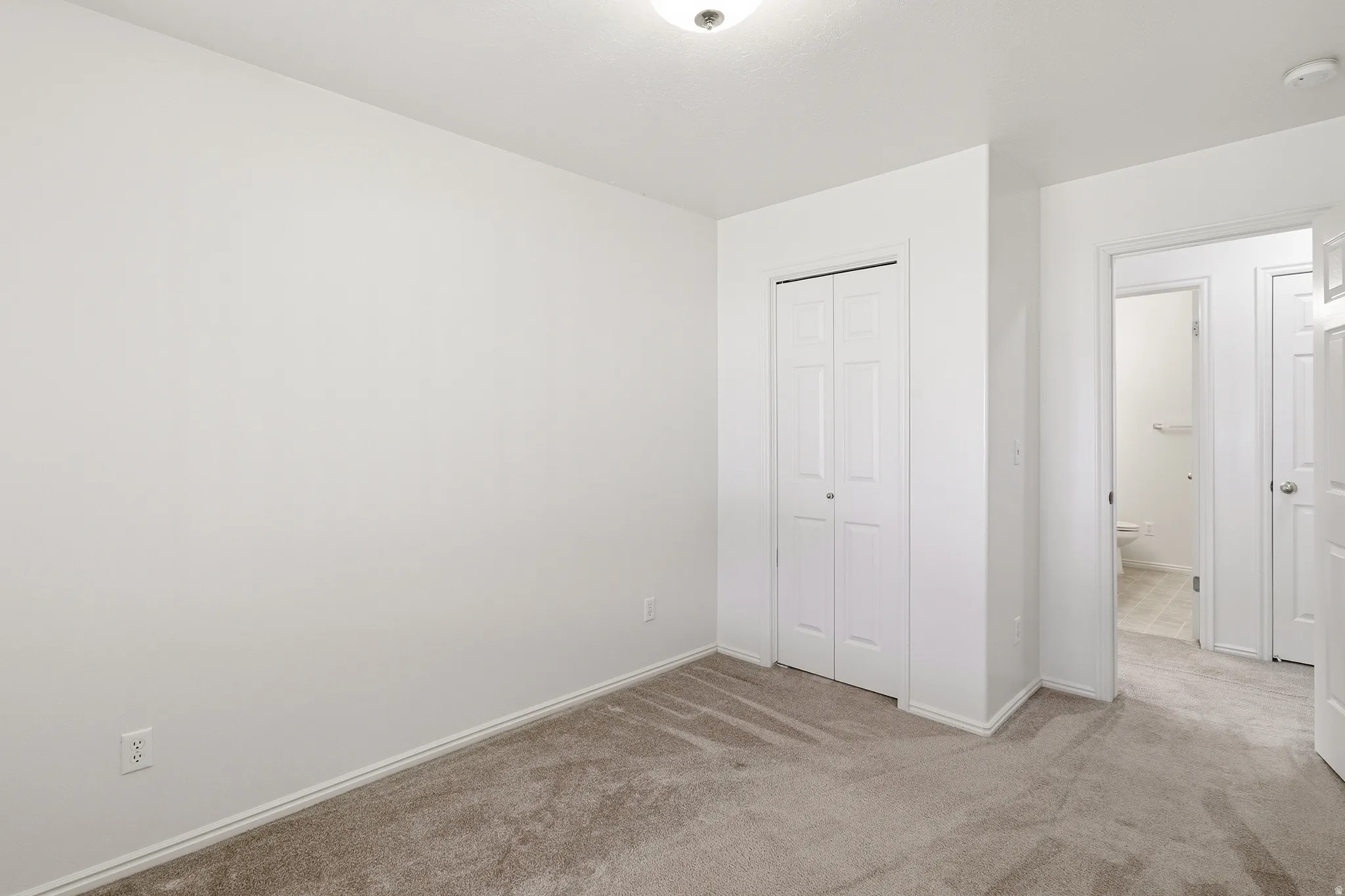 Neutral wall finishes and light-toned carpet flooring create a versatile interior