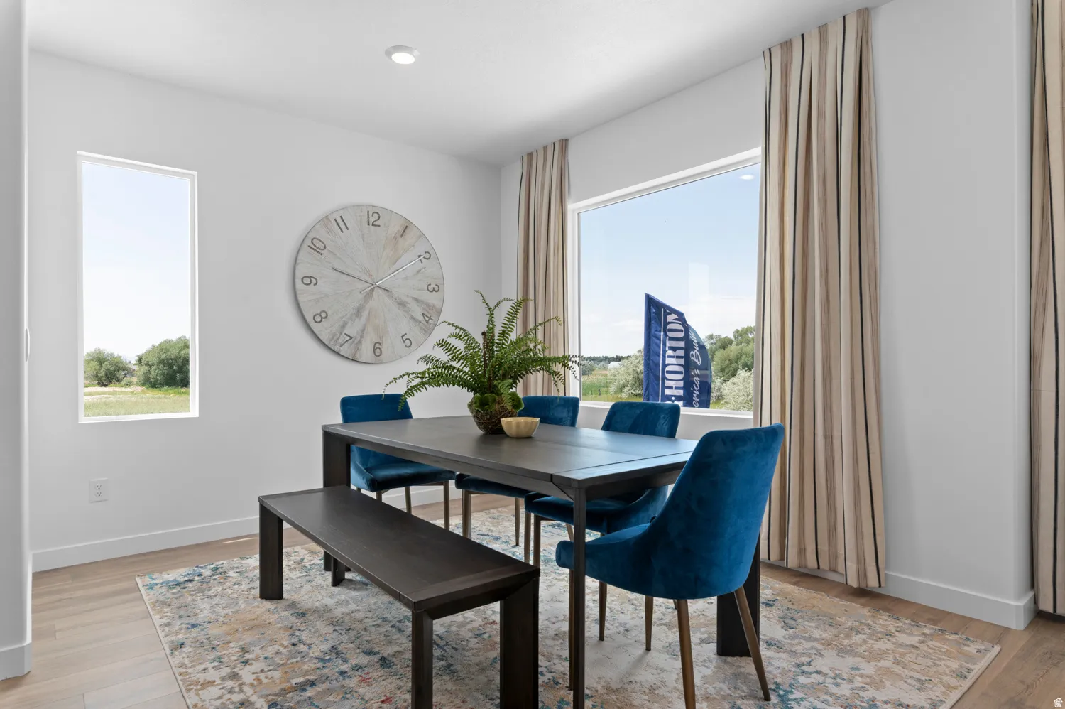 Dining area featuring wood-finish flooring, a rectangular window, a large picture window, recessed lighting, and white baseboards