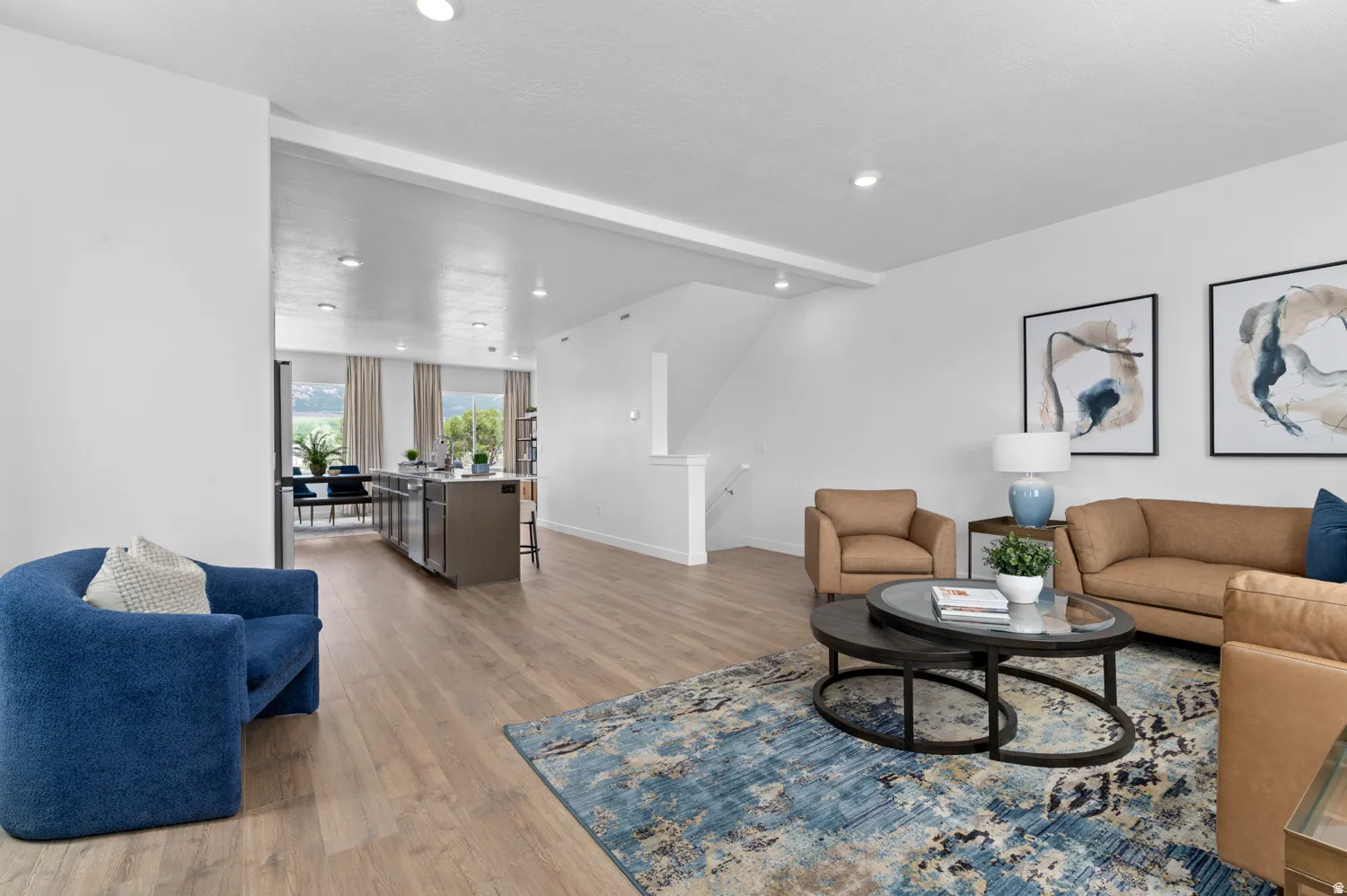 Open-concept living area with wood-finish flooring, recessed lighting, and a neutral color palette