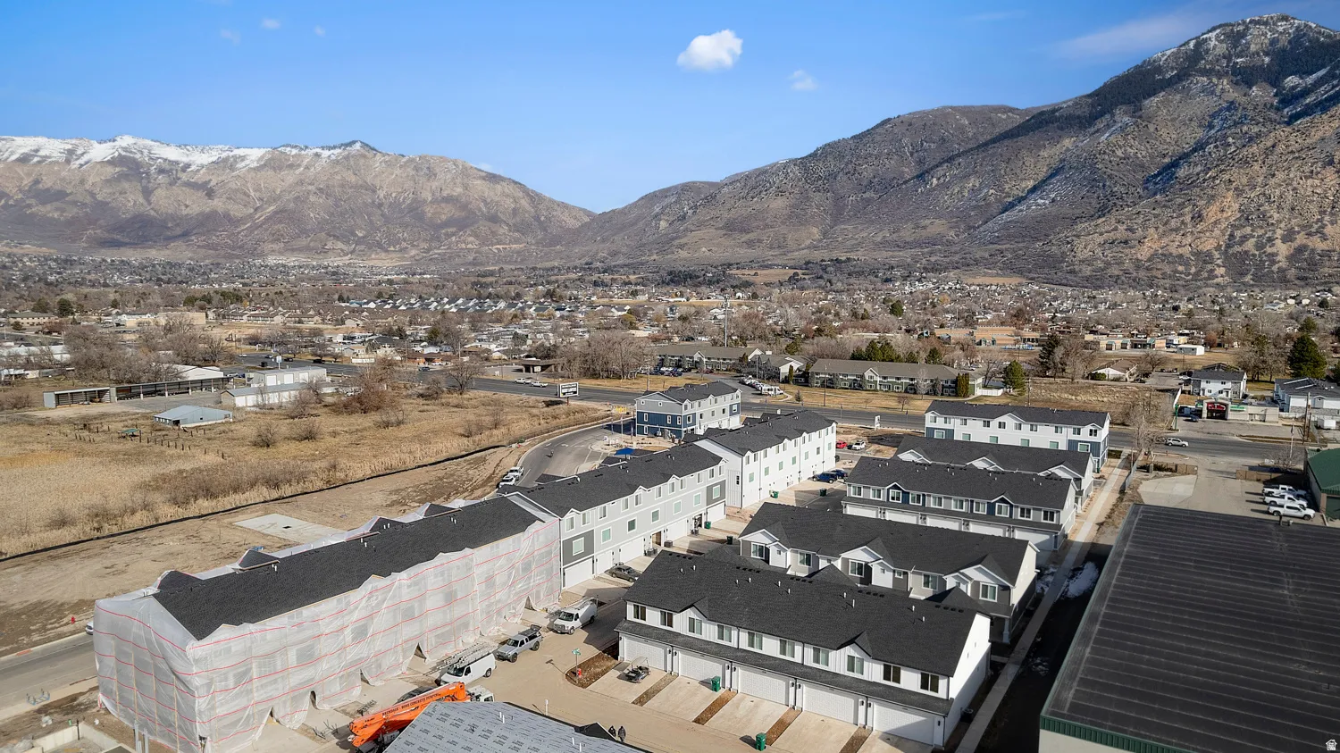 Newly constructed townhome community featuring varied architectural styles and dark shingle roofing