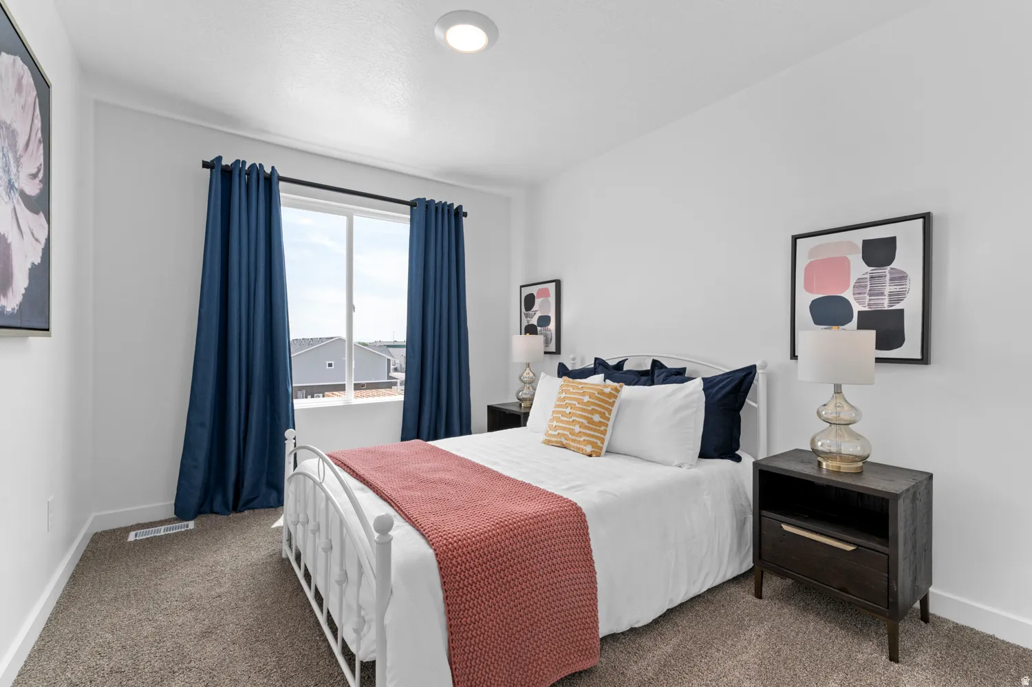Bright bedroom featuring a large window with white trim, wall-to-wall carpeting, and recessed ceiling lighting
