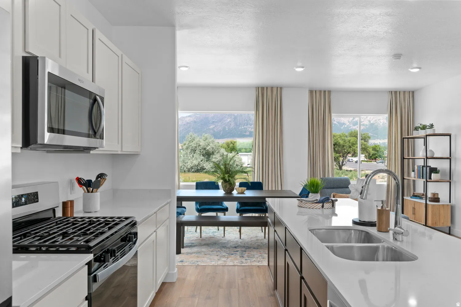 Modern kitchen featuring white cabinetry, stainless steel appliances, and a gas range