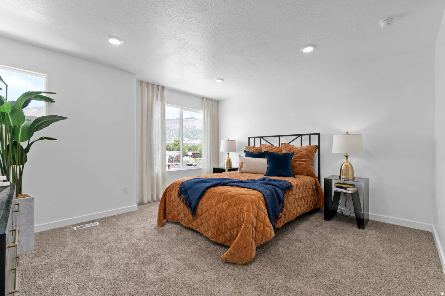 Carpeted bedroom with recessed lighting and a window offering a mountain backdrop