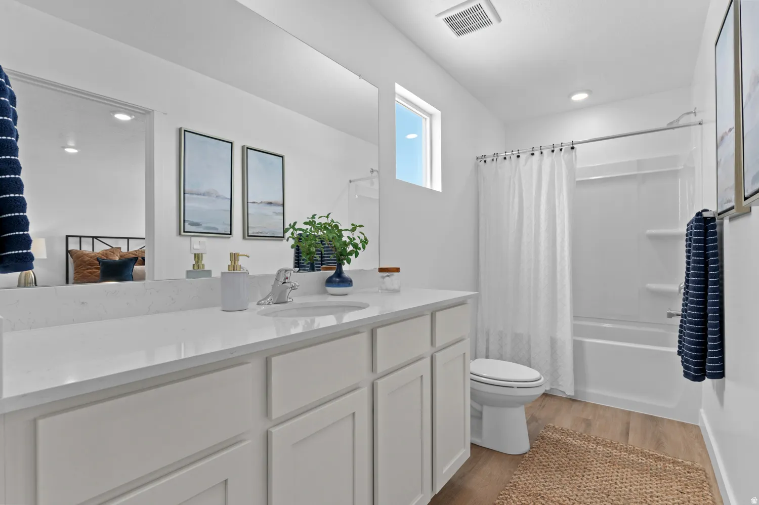 Bathroom featuring a white vanity with a light-toned countertop, a rectangular sink, and a chrome faucet