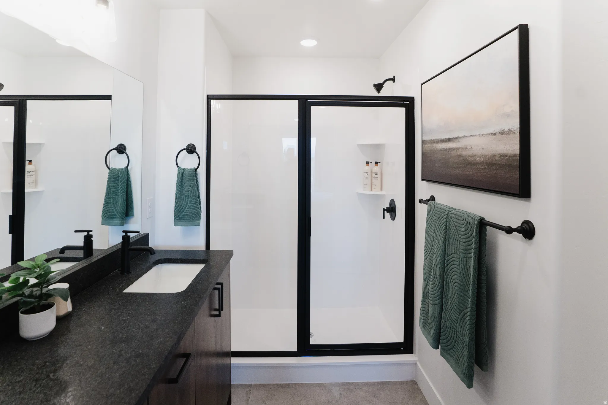 Bathroom featuring a dark wood-finish vanity with a rectangular undermount sink and matte black fixtures
