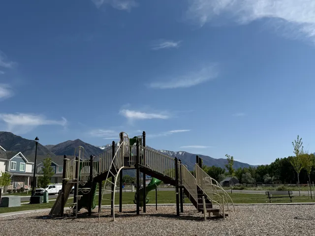 Outdoor play structure on a wood chip base with mountain scenery