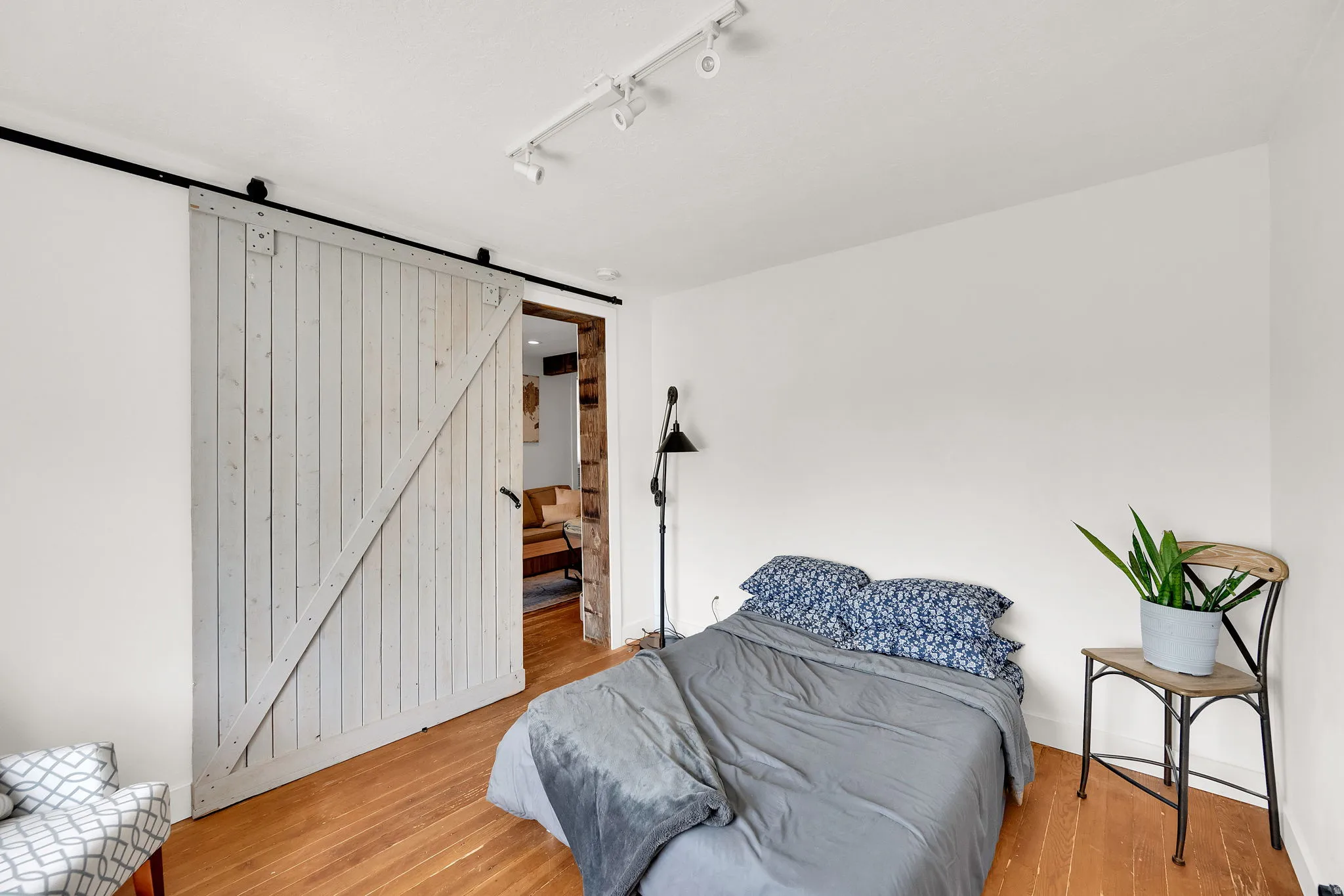 Bright room featuring wood-finish flooring and a white barn door on a black rail system