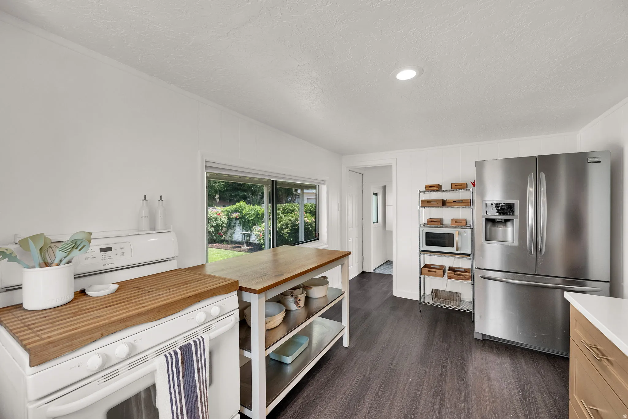 Kitchen featuring wood-finish flooring, a stainless steel French door refrigerator, and recessed lighting