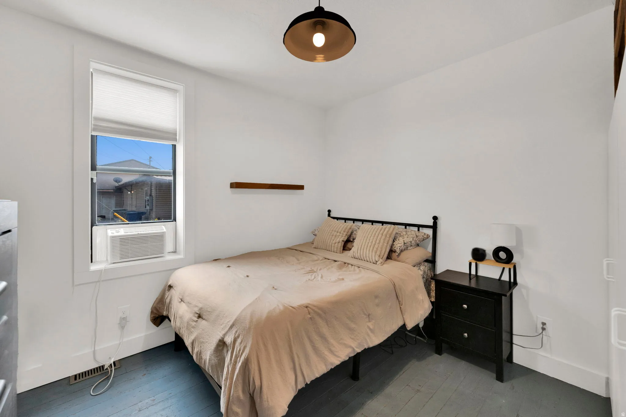 Interior room with light-toned walls and blue-painted wood-finish flooring