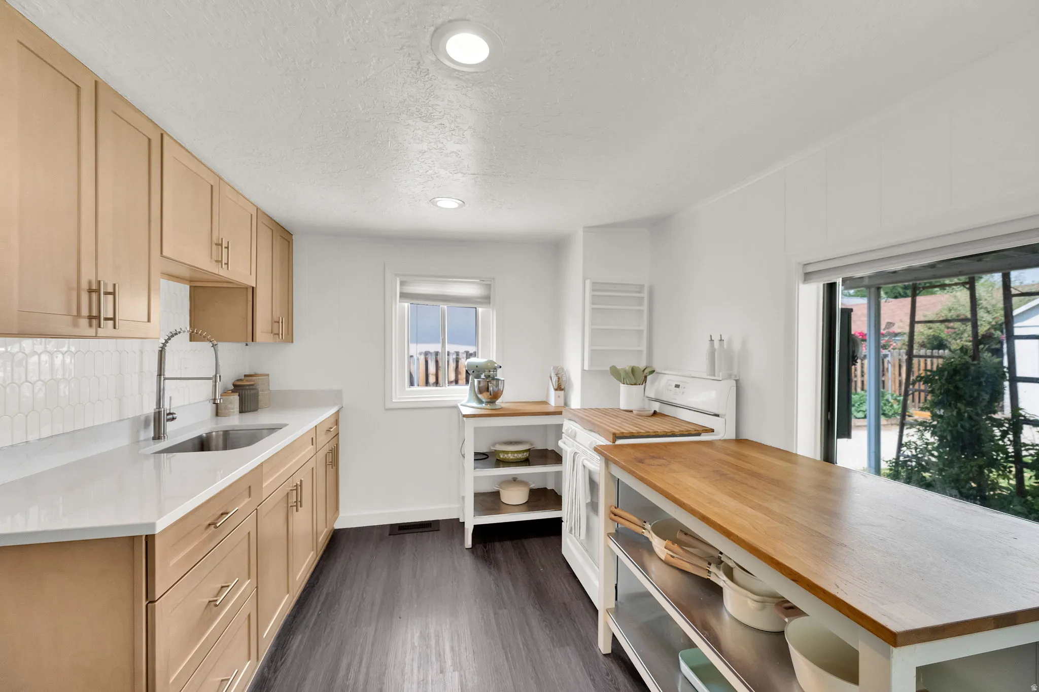 Bright kitchen featuring wood-finish flooring and light-toned cabinetry