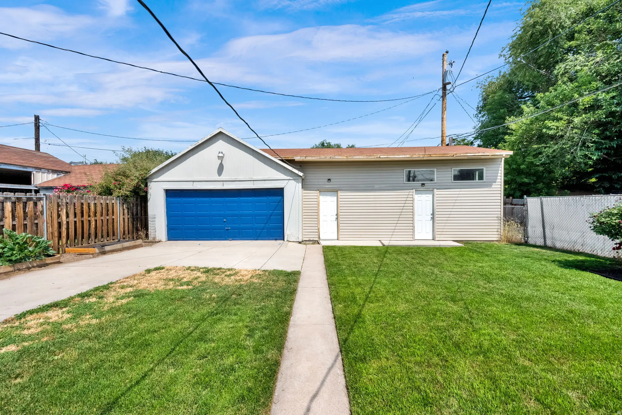 Detached garage featuring a blue roll-up door and a side entry
