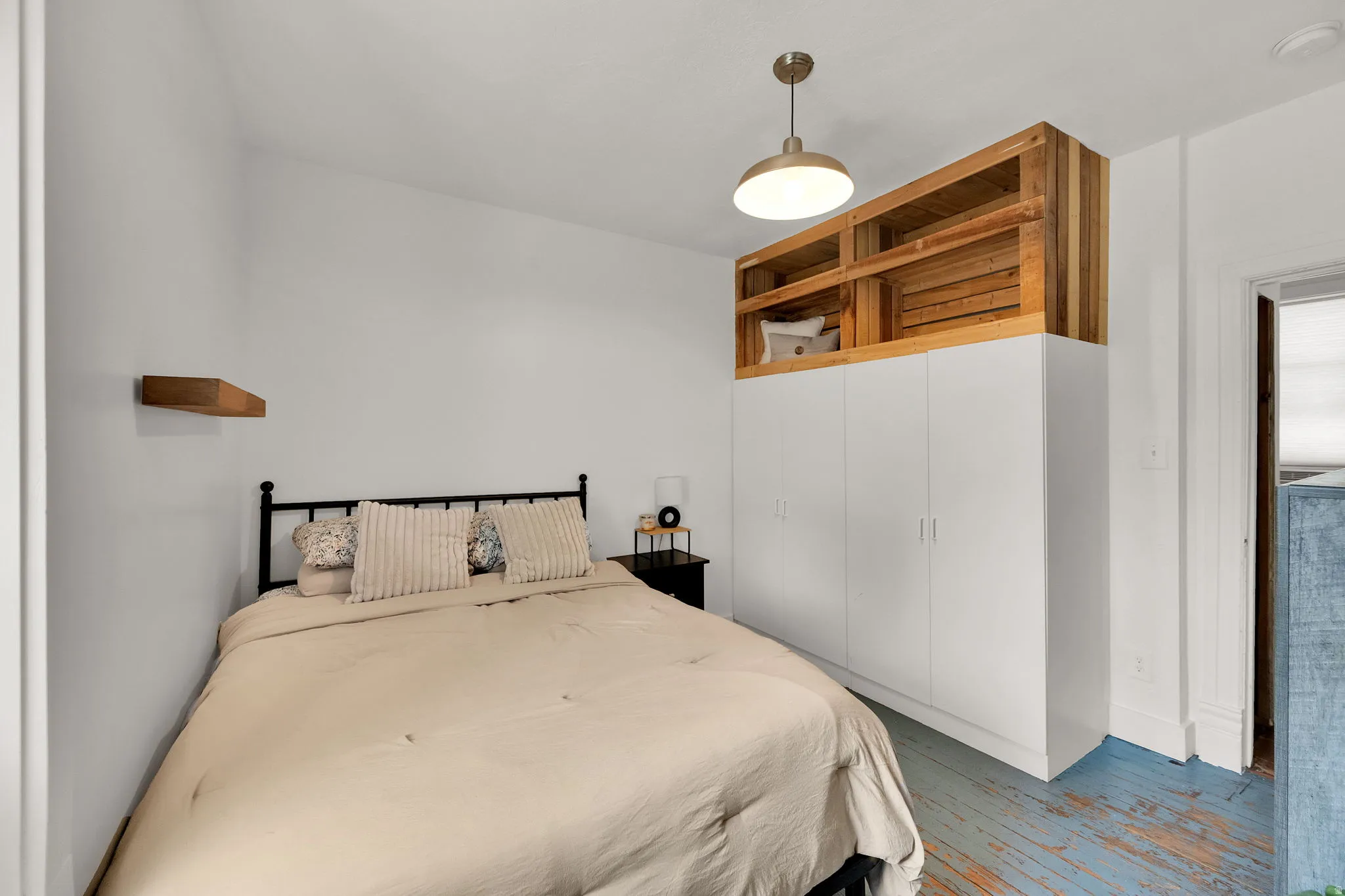 Integrated white cabinetry with natural wood-finish open shelving, complemented by a contemporary flush-mount ceiling light