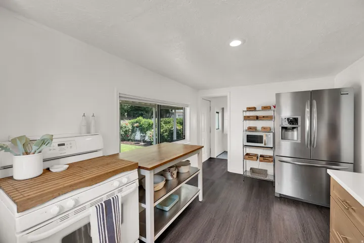Kitchen featuring wood-finish flooring, a stainless steel French door refrigerator, and recessed lighting