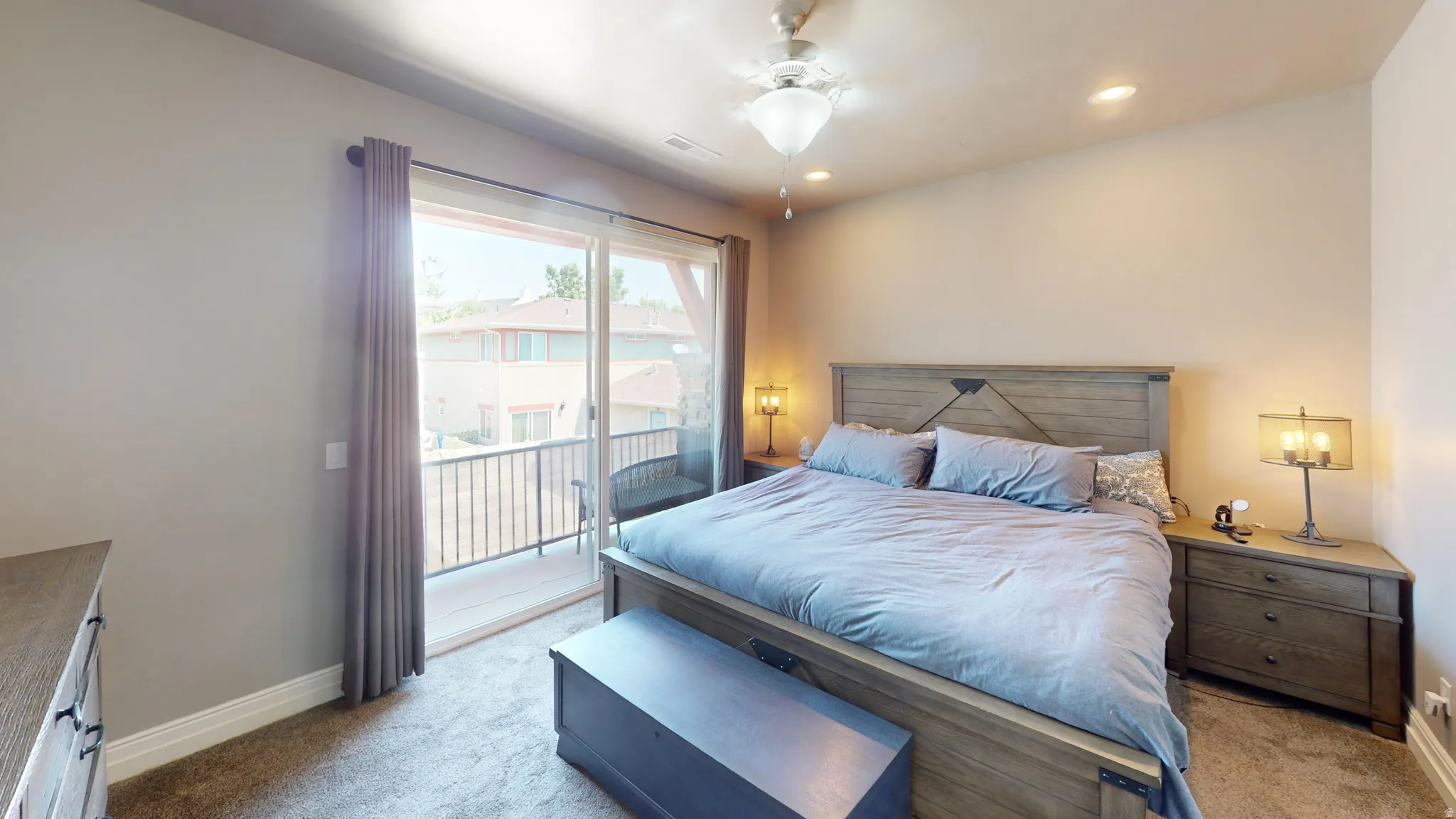 Bedroom featuring sliding glass door access to a private balcony with metal railings