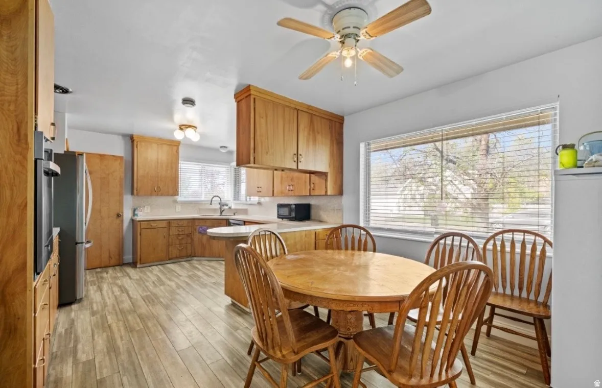Spacious kitchen featuring wood-finish flooring, ample wood cabinetry, and a large window