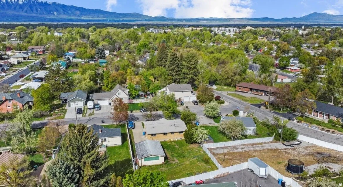 Expansive neighborhood with diverse architectural styles, mature trees, and mountainous backdrop
