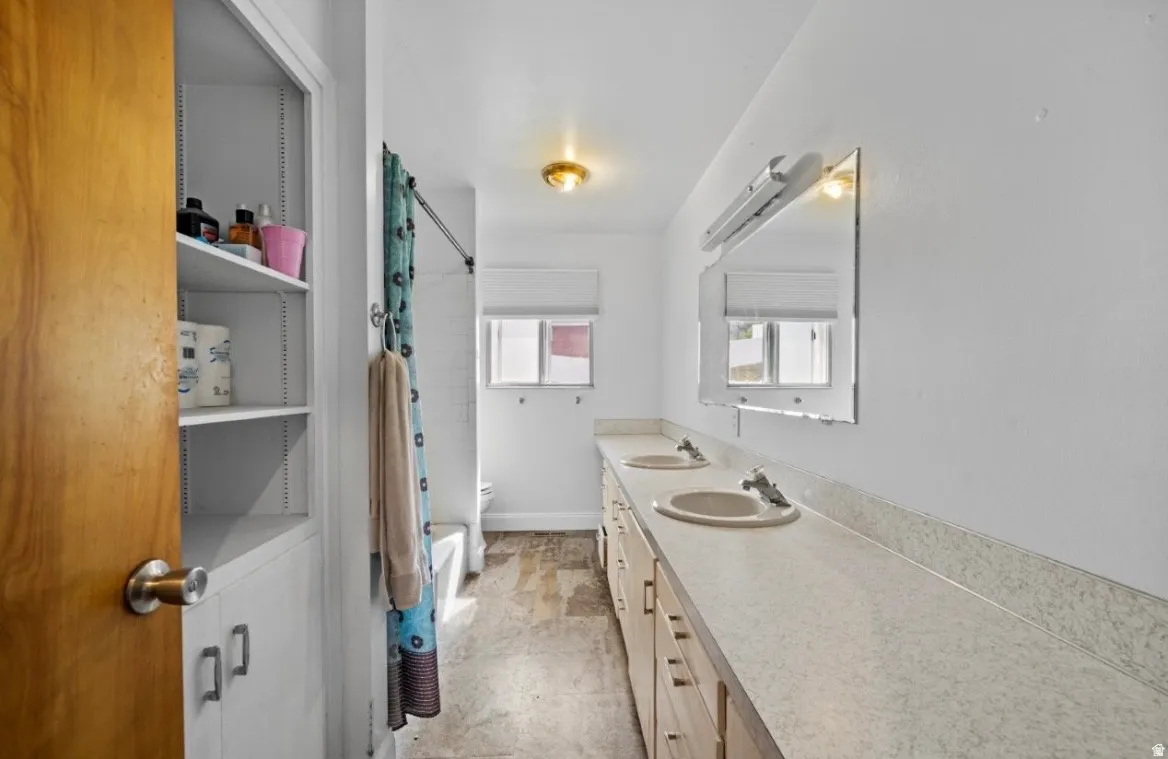 Bathroom featuring a dual vanity with integrated sinks and a long countertop