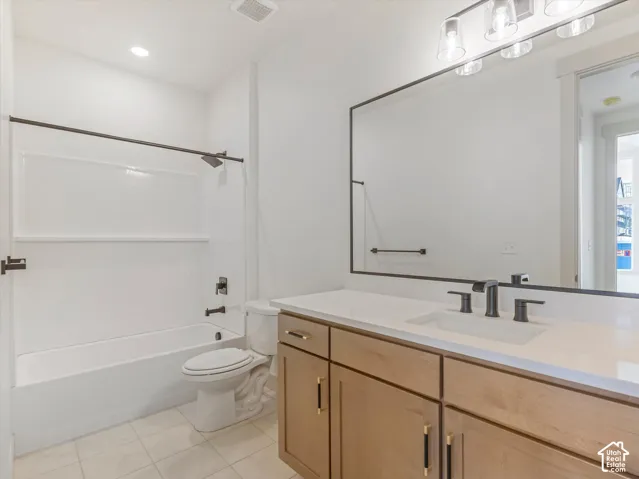 Light wood-finish vanity with gold-tone hardware, integrated single-basin sink, and matte black faucet