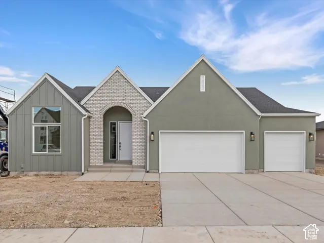 Contemporary exterior with board and batten siding, light brick archway, and stucco finishes