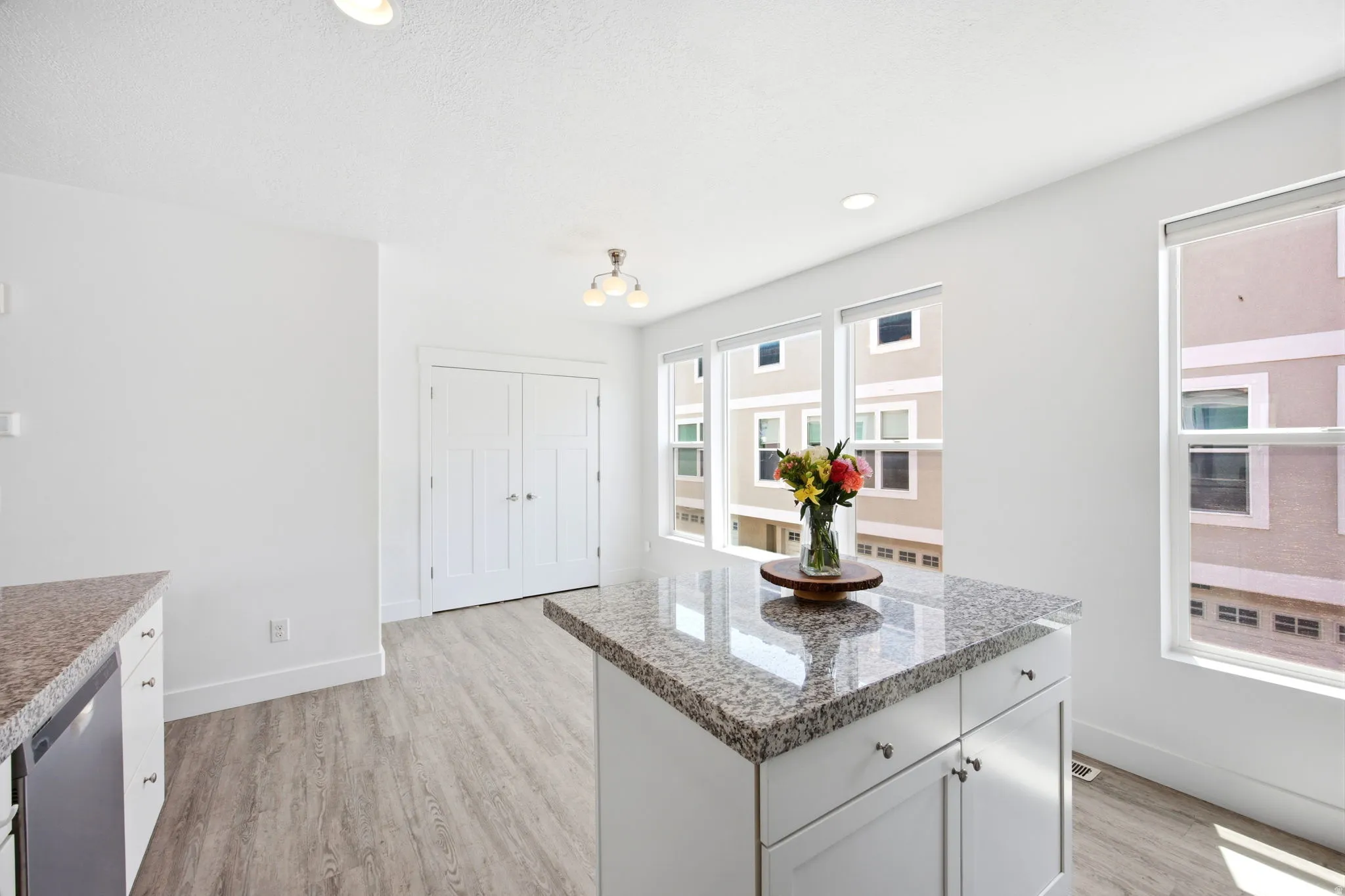 Kitchen island with granite countertop and white cabinetry