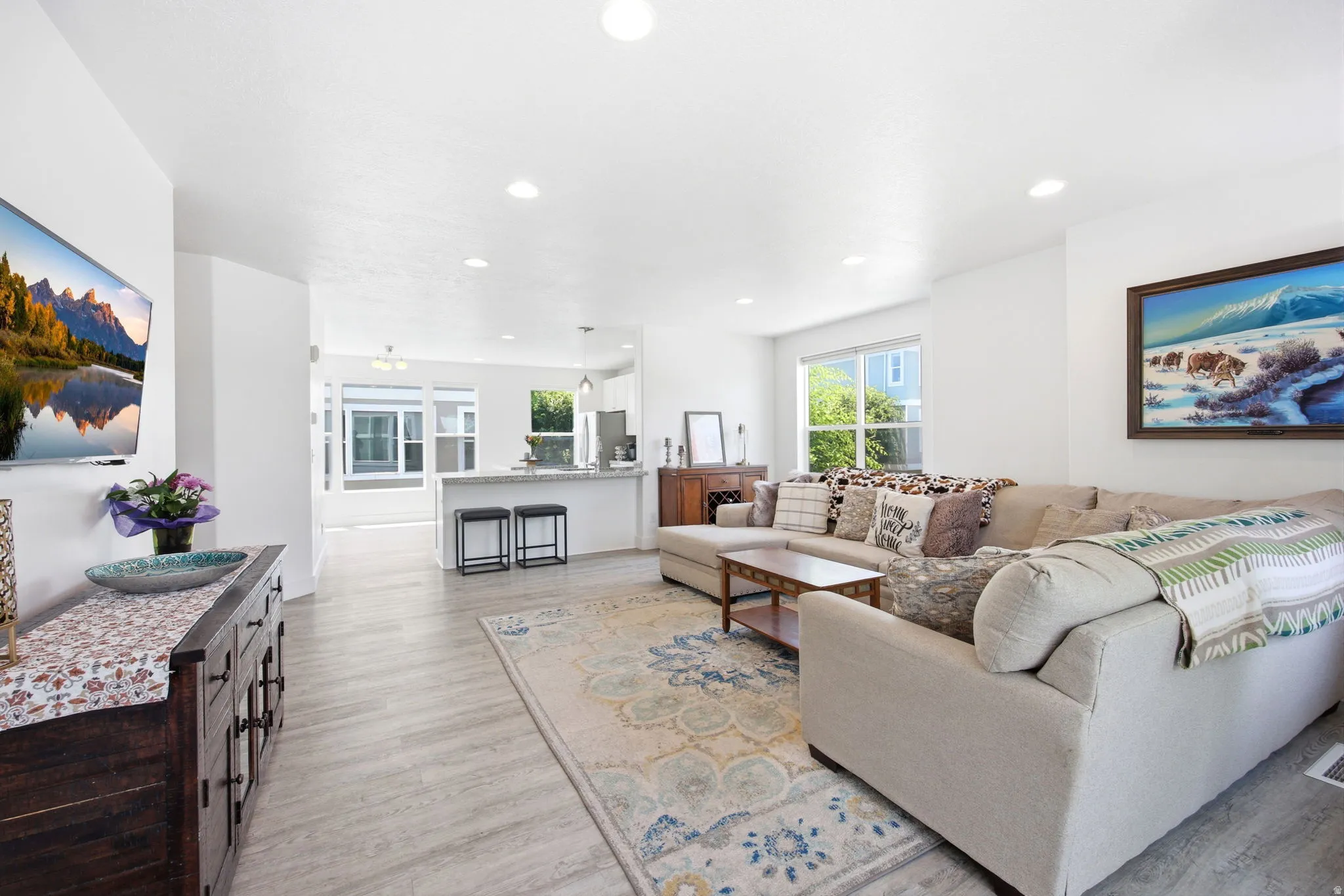 Open concept living space featuring recessed lighting, light wood-finish flooring, and white walls