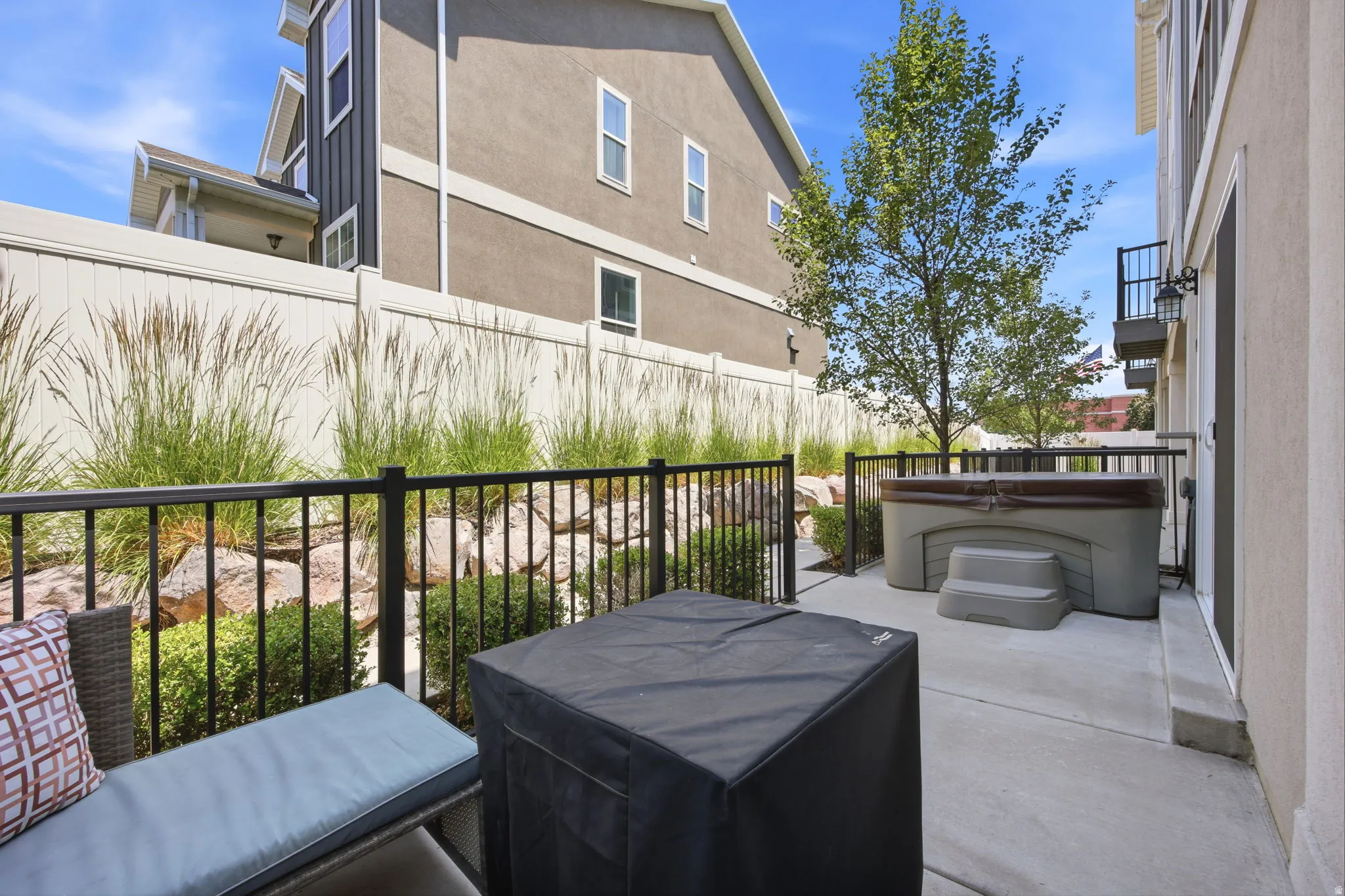 Expansive concrete patio area featuring a built-in hot tub