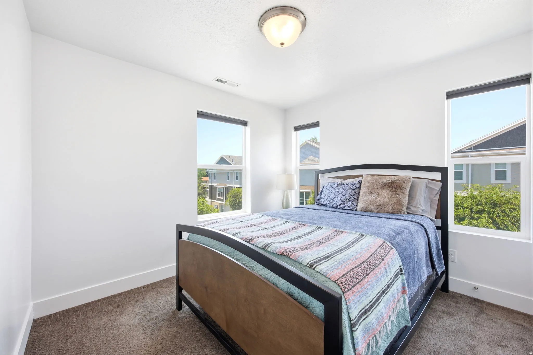 Neutral color palette featuring ample natural light from multiple windows, recessed lighting, and carpeted flooring