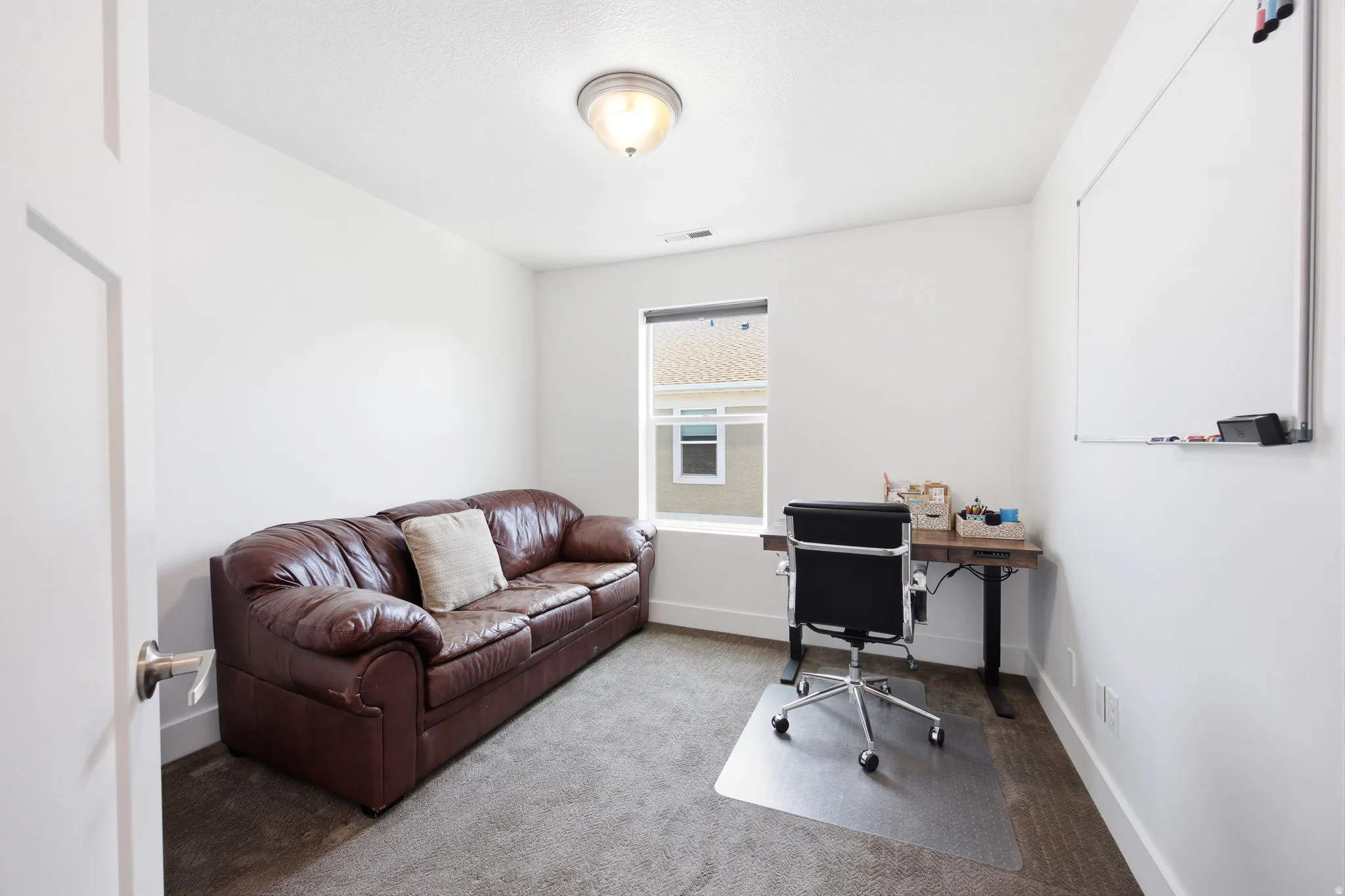 Versatile room featuring white walls, a single window, and a ceiling-mounted light fixture