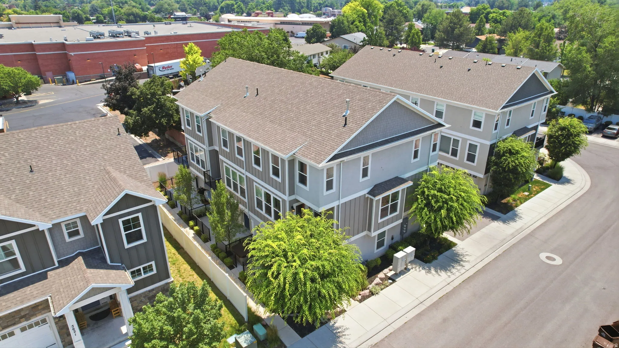 Contemporary townhome featuring multi-level construction, a neutral color palette, multiple windows, and landscaped grounds