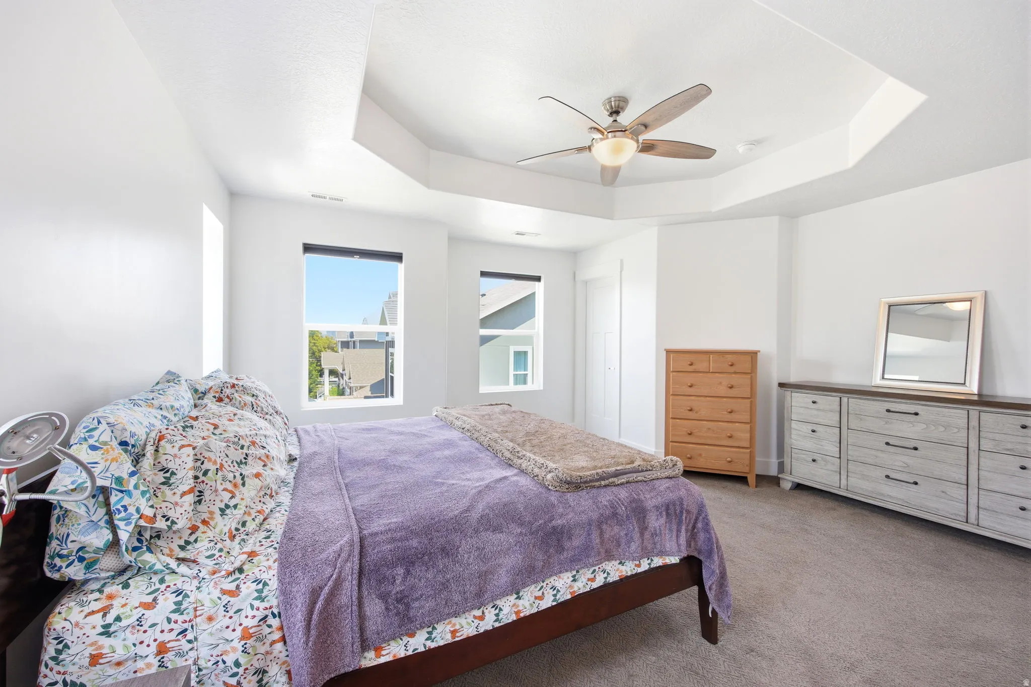 Bedroom featuring a tray ceiling, ceiling fan with integrated lighting, recessed lighting, and carpet flooring